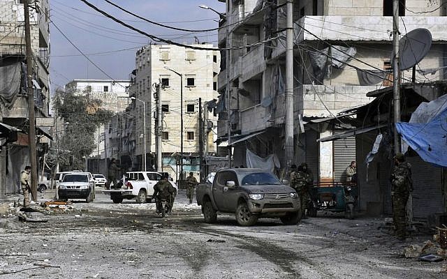 Photo released by the Syrian official news agency SANA, shows Syrian troops march through the streets of east Aleppo, Syria, December 12, 2016. (SANA via AP) Photo released by the Syrian official news agency SANA, shows Syrian troops march through the streets of east Aleppo, Syria, December 12, 2016. (SANA via AP)