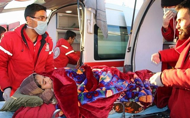 Members of the Syrian Arab Red Crescent carrying a girl on a stretcher, while arriving in western rural Aleppo, Syria, Dec. 15, 2016 (Thiqa News via AP)