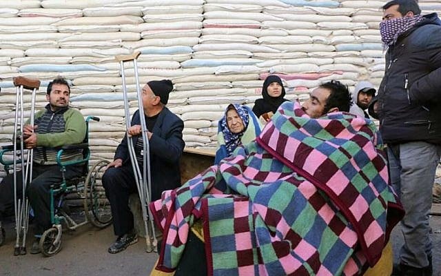 This image released on Thursday, Dec. 15, 2016 by Aleppo 24, shows residents gathering for evacuation from eastern Aleppo, Syria. (Aleppo 24 via AP)