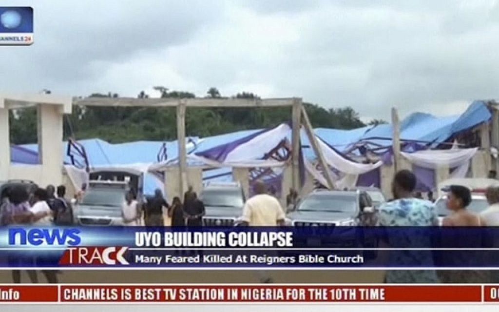 In this image taken from video people stand at the scene after the roof of The Reigners Bible Church International collapsed onto worshipers killing dozens in Uyo, southern Nigeria, December 10, 2016. (Channels TV via AP)