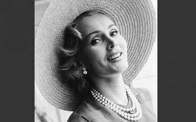  In a July 14, 1955 file photo, Zsa Zsa Gabor arrives at London Airport from Paris, in a Crimson dress and a straw hat. AP)