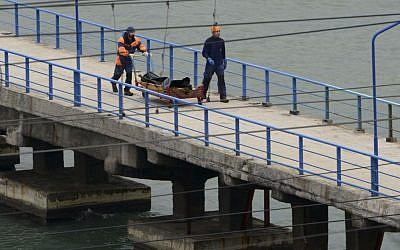 Russian rescue workers carry a body from the wreckage of the crashed plane, at a pier just outside Sochi, Russia, December 25, 2016. (AP Photo/Viktor Klyushin)