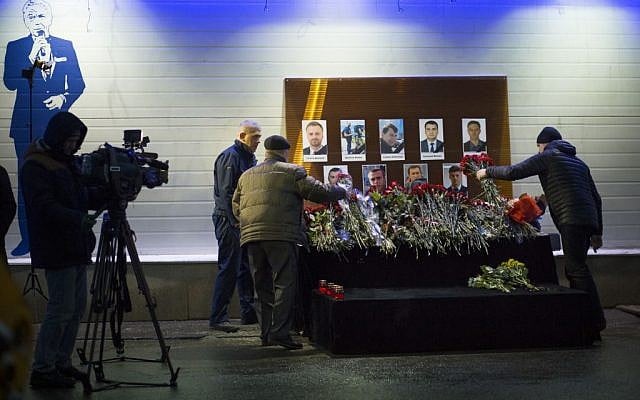 Flowers are offered in front of portraits of Russian TV journalists who were aboard a crashed military plane, displayed at the main TV building in Moscow, Russia, December 26, 2016. (AP/Alexander Zemlianichenko)