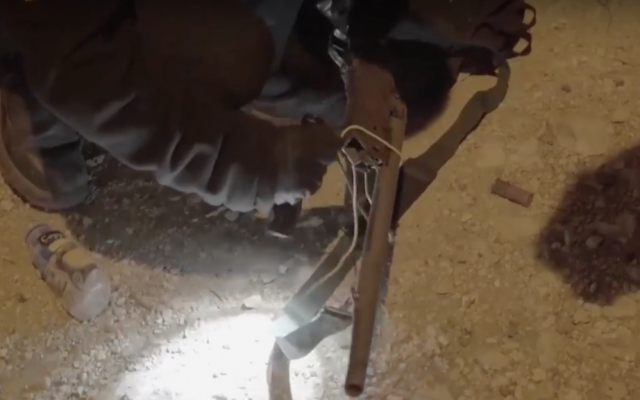 An IDF soldier holds a gun believed to have been used in four shooting attacks on an army post outside the Ofra settlement in the West Bank. (Screen capture: IDF Spokesperson's Unit)
