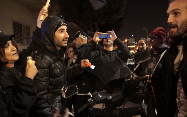 Demonstrators from the Movement to Free South Tel Aviv, an anti-immigration group, argue with attendees of the Nightlight festival in south Tel Aviv, December 24, 2016. (Luke Tress/Times of Israel)