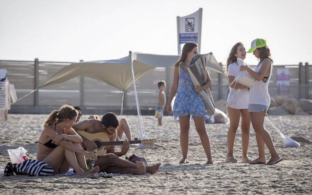 Israelis enjoy the warm weather on the beach in Tel Aviv, October 03, 2016. (Nati Shohat/FLASH90)
