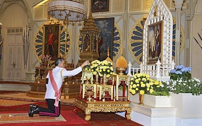 Thailand 's new king Maha Vajiralongkorn Bodindradebayavarangkun pays his respects to a portrait of the late Thai King Bhumibol Adulyadej and Thai Queen Sirikit at the Dusit Palace Thursday, December 1, 2016 in Bangkok, Thailand. (Bureau of the Royal Household via AP)