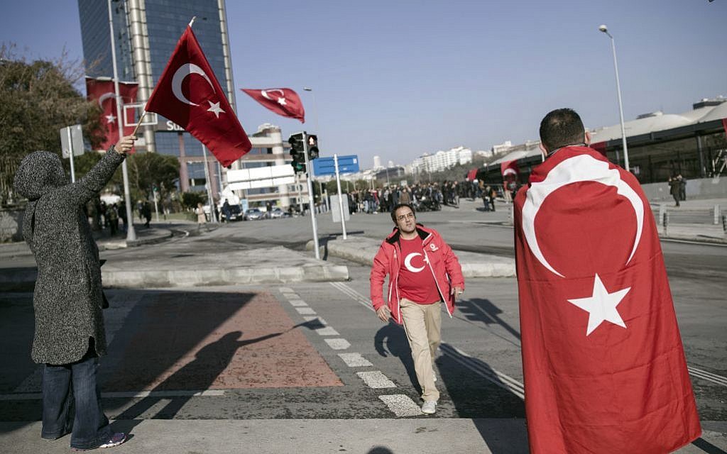 People walk past the Besiktas football club stadium Vodafone Arena in Istanbul, Sunday, December 11, 2016 following a late Saturday explosion. (AP/Halit Onur Sandal)