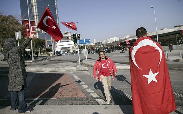 People walk past the Besiktas football club stadium Vodafone Arena in Istanbul, Sunday, December 11, 2016 following a late Saturday explosion. (AP/Halit Onur Sandal)