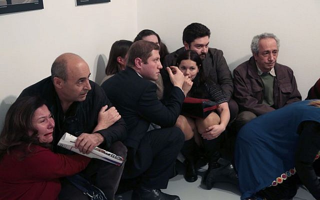 People crouch in a corner after Andrei Karlov, the Russian Ambassador to Turkey, was shot at a photo gallery in Ankara, Turkey, December 19, 2016. (AP/Burhan Ozbilici) People crouch in a corner after Andrei Karlov, the Russian Ambassador to Turkey, was shot at a photo gallery in Ankara, Turkey, December 19, 2016. (AP/Burhan Ozbilici)
