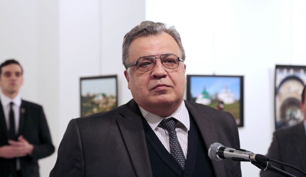Andrei Karlov, the Russian ambassador to Turkey, pauses during a speech at a photo exhibition, moments before a gunman, identified as Mevlut Mert Altintas, seen standing in the background, left, fatally shoots him in Ankara, December 19, 2016 (AP/Burhan Ozbilici) Andrei Karlov, the Russian ambassador to Turkey, pauses during a speech at a photo exhibition, moments before a gunman, identified as Mevlut Mert Altintas, seen standing in the background, left, fatally shoots him in Ankara, December 19, 2016 (AP/Burhan Ozbilici)