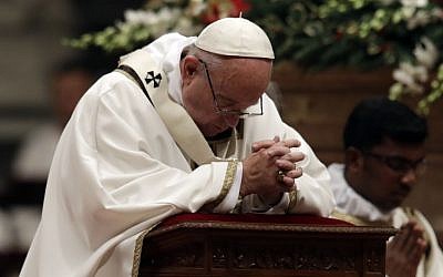 Pope Francis kneels as he celebrates the Christmas Eve Mass in St. Peter's Basilica at the Vatican, Saturday, Dec. 24, 2016. (AP Photo/Alessandra Tarantino)