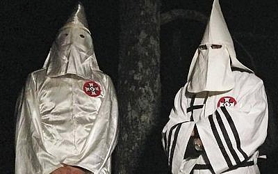 Two masked Ku Klux Klansmen stand on a muddy dirt road during an interview near Pelham, NC on Dec. 2, 2016. (AP Photo/Jay Reeves)