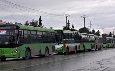 Buses wait to evacuate civilians from eastern Aleppo, December 14, 2016. / AFP PHOTO / George OURFALIAN