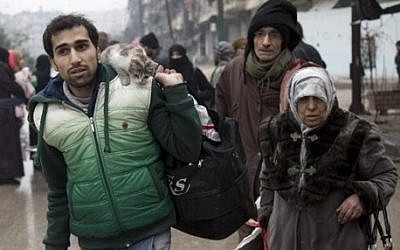 Syrians leave a rebel-held area of Aleppo for the government-held side on December 13, 2016, during an operation by Syrian government forces to retake the embattled city.  (AFP PHOTO / KARAM AL-MASRI)