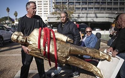 The golden statue of Prime Minister Benjamin Netanyahu is taken down at Rabin square in Tel Aviv, December 6, 2016. (Miriam Alster/Flash90)