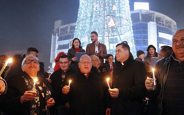 Iraqis gather at al-Mansour Square with Archbishop Louis Sako, center, patriarch of the Catholic Church in Iraq, during Christmas and New Year's Eve celebrations in the capital Baghdad on December 31, 2016. (Sabah Arar/AFP)