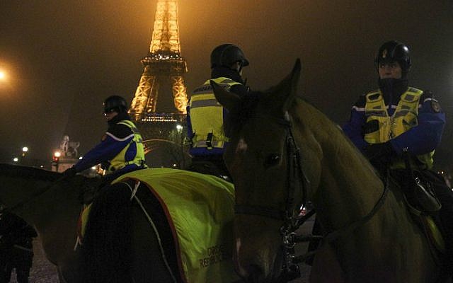 Mounted police patrol as revelers gather at the foot of the Eiffel Tower for New Year's celebrations on January 1, 2017 in Paris. (Martin Bertrand/AFP)