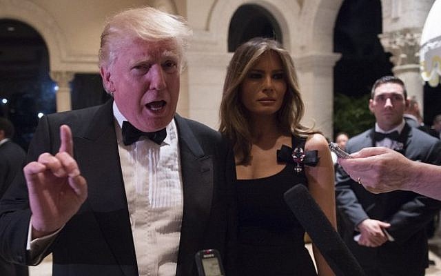 US President-elect Donald Trump answers questions from reporters accompanied by wife Melania for a New Year's Eve party, at Mar-a-Lago in Palm Beach, Florida, December 31, 2016. (AFP/DON EMMERT)
