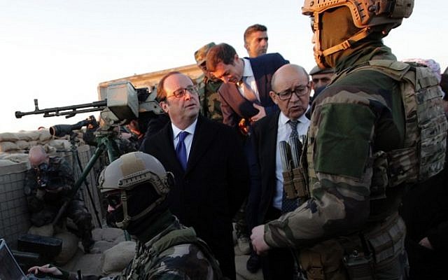 French President Francois Hollande, center, and French defense minister Jean-Yves Le Drian, center-right, meet French soldiers operating a drone as they visit a military outpost on the outskirts of the northern city of Mosul, Iraq, January 2, 2017. (AFP/Christophe Ena)