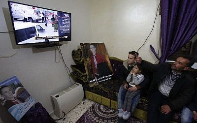 Yusri the father of Abdul Fatah al-Sharif watches on television the verdict of the trial of Israeli soldier Elor Azaria who killed their son, at their family home in the West Bank town of Hebron on January 4, 2017. AFP/HAZEM BADER)
