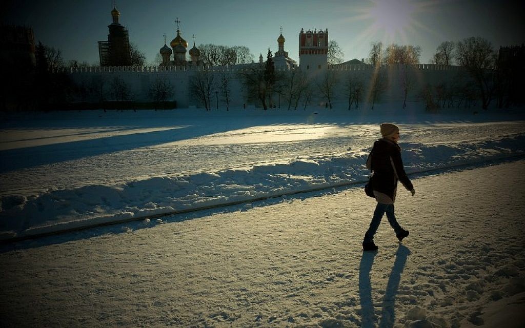 A woman walks along a snow-covered frozen pond near Moscow's Novodevichy Convent on January 11, 2017. (AFP/Yuri KADOBNOV)