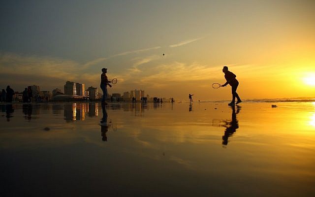 Palestinians play tennis on the beach during the sunset in Gaza City on January 11, 2017. (AFP/MOHAMMED ABED) Palestinians play tennis on the beach during the sunset in Gaza City on January 11, 2017. (AFP/MOHAMMED ABED)