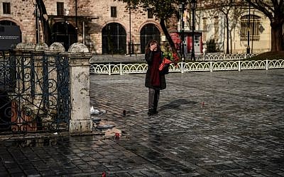 Sibel Satiroglu, a tour guide places red carnations Sultanahmet Square, the site where 12 of her German clients were killed last year in a bombing, in Istanbul on January 12, 2017.(AFP PHOTO / OZAN KOSE)