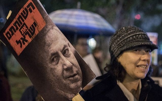 An Israeli left-wing supporter holds a banner reading in Hebrew: ''corrupted the Israelis'' during a rally against Israeli Prime Minister Benjamin Netanyahu and government policies, on January 14, 2017, at the Rabin Square in the city of Tel Aviv (AFP PHOTO / JACK GUEZ) An Israeli left-wing supporter holds a banner reading in Hebrew: ''corrupted the Israelis'' during a rally against Israeli Prime Minister Benjamin Netanyahu and government policies, on January 14, 2017, at the Rabin Square in the city of Tel Aviv (AFP PHOTO / JACK GUEZ)