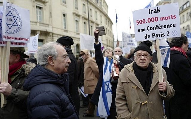 A man holds a sign reading "Iraq 500000 dead: a Paris Conference?" during a protest rally against the Paris Middle East peace conference, in Paris January 15, 2017 . (AFP/Pierre CONSTANT)