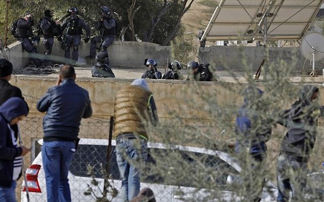 Israeli policemen (background) take aim as they hold a position atop a building in the Bedouin unrecognized village of Umm al-Hiran in the Negev desert. January 18, 2017. (AFP Photo/Menahem Kahana)