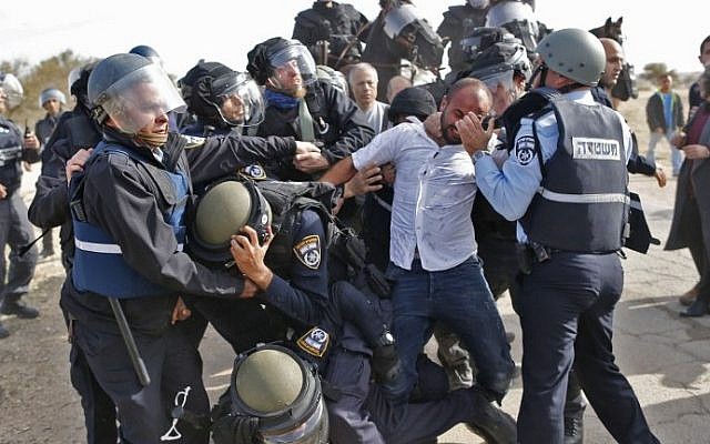 Israeli policemen detain a Bedouin man during a protest against home demolitions on January 18, 2017, in the unrecognized Bedouin village of Umm al-Hiran in the Negev desert. (AFP Photo/Ahmad Gharabli)