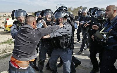 Israeli policemen clash with a Bedouin man following a protest against home demolitions in the Bedouin village of Umm al-Hiran, January 18, 2017. (AFP/AHMAD GHARABLI)