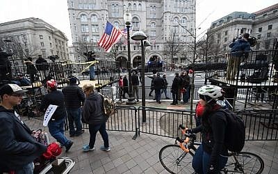 People pass by the Trump International Hotel one day ahead of the inauguration of US President-elect Donald Trump, in Washington, DC on January 19, 2017. (AFP/Robyn BECK)