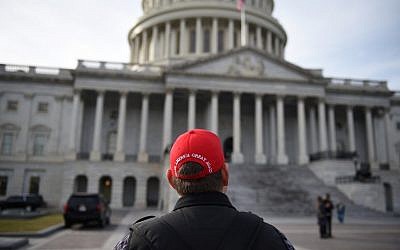 A supporter wears a "Make America Great Again" cap look on outside the US Capitol one day ahead of the inauguration of US President-election Donald Trump, in Washington, DC on January 19, 2017.  (AFP/Robyn BECK)