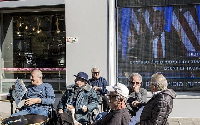 Israelis relax at a cafe in front of giant TV screens playing footage of US President-elect Donald Trump on January 20, 2017 in the coastal city of Tel Aviv prior to his inauguration as the 45th president of the United States. (AFP PHOTO / JACK GUEZ)