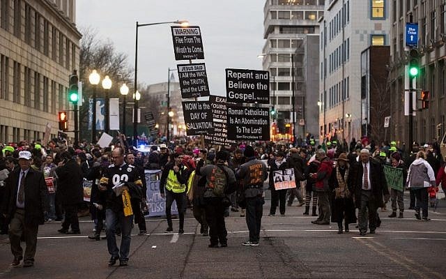 Demonstrators hold signs before the inauguration of President-elect Donald Trump January 20, 2017 in Washington, DC (AFP PHOTO / ZACH GIBSON)
