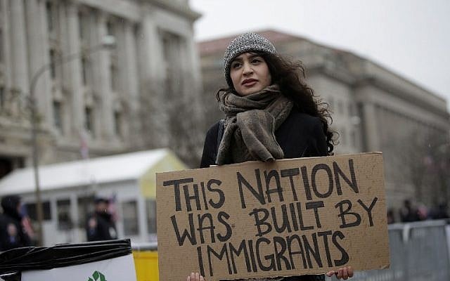 A woman holds a sign before the start of the Presidential Inauguration of Donald Trump at Freedom Plaza on January 20, 2017 in Washington, DC. ( AFP PHOTO / Joshua LOTT)