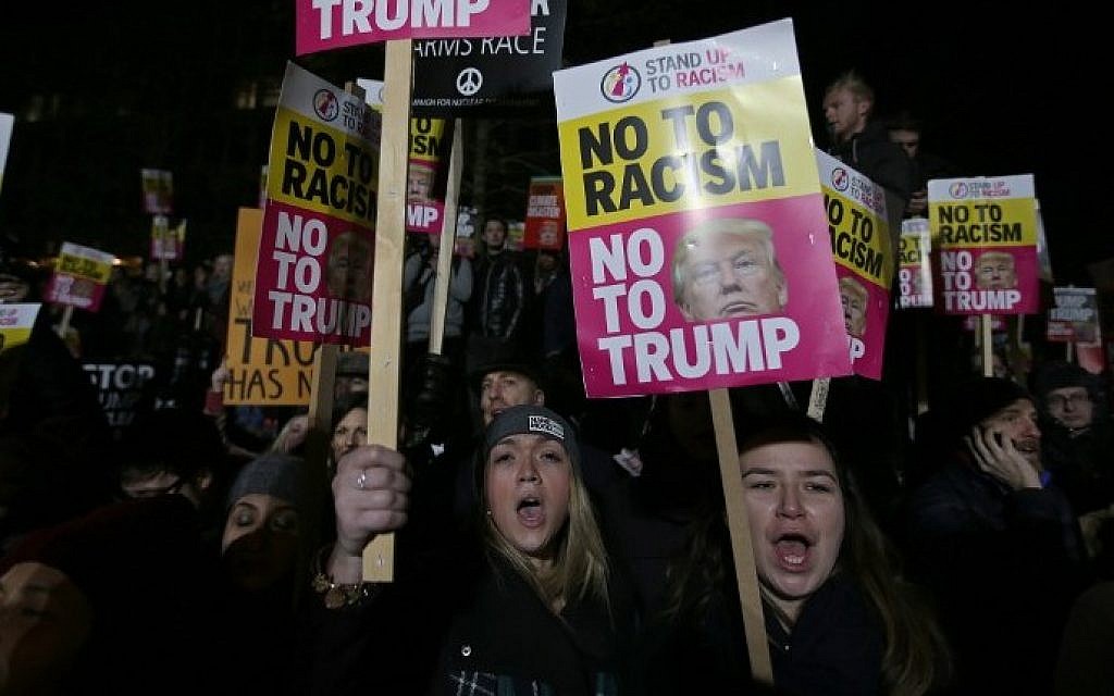 Demonstrators hold placards as they protest outside the US Embassy in London on January 20, 2017, to coincide with the inauguration of Donald Trump as the 45th president of the United States. (AFP PHOTO / Daniel LEAL-OLIVAS)