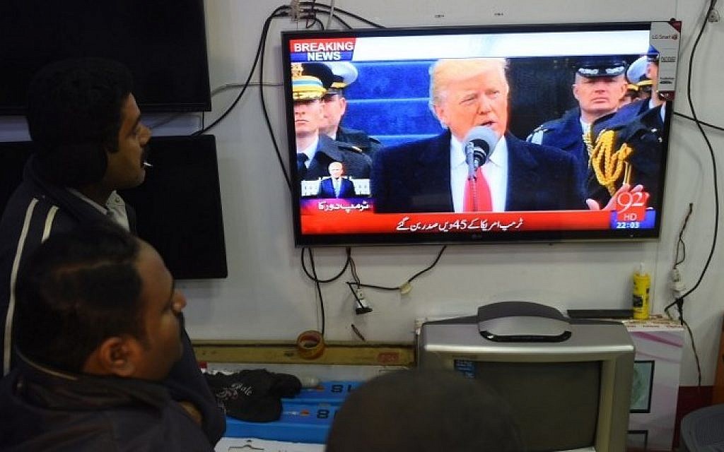 Pakistani residents watch the TV broadcast of the inaugural ceremony of new US President Donald Trump at a market in Karachi, on January 20, 2017. (AFP PHOTO / RIZWAN TABASSUM)
