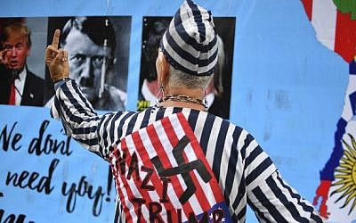An activist dressed in Nazi concentration camp uniform pictured during a protest against US President Donald Trump in front of the US Embassy in Mexico City on January 20, 2017. (AFP PHOTO / YURI CORTEZ)