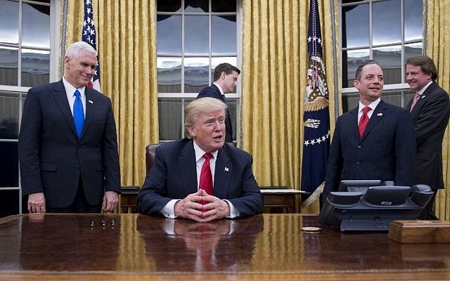 US President Donald Trump, center, speaks to the press at his desk in the Oval Office of the White House in Washington, DC, January 20, 2017. (AFP PHOTO / JIM WATSON) US President Donald Trump, center, speaks to the press at his desk in the Oval Office of the White House in Washington, DC, January 20, 2017. (AFP PHOTO / JIM WATSON)