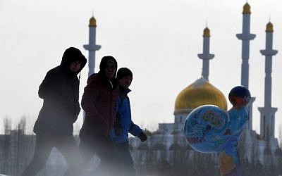 Men walk along a street, with the Nur-Astana mosque seen in the background, in Astana, Kazakhstan on January 22, 2017. (Kirill Kudryavtsev/AFP)