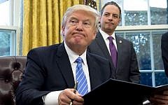 US President Donald Trump signs an executive order as then chief of ftaff Reince Priebus looks on in the Oval Office of the White House, on January 23, 2017. (AFP/Saul Loeb)