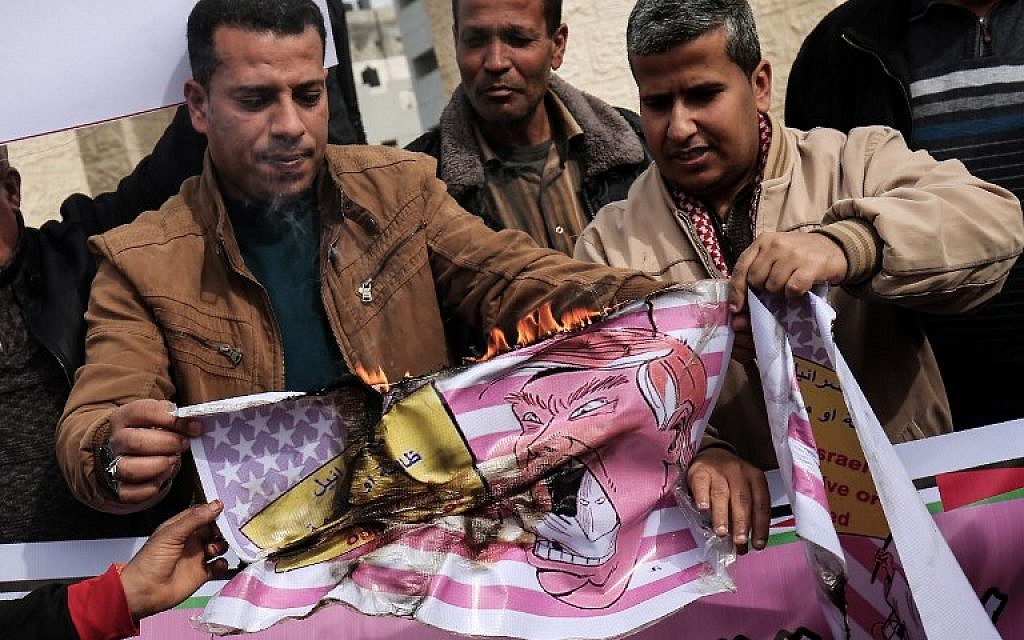 Palestinian protesters  in Rafah in the southern Gaza Strip burn a placard depicting US President Donald Trump during a demonstration against his pledge to move his country's embassy to Jerusalem, on January 24, 2017.  (AFP PHOTO / SAID KHATIB)