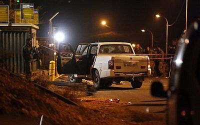 Israeli forensic policemen and security forces inspect the site where a Palestinian man drove at a bus stop in an attempted car-ramming attack before being shot dead, near the West Bank settlement of Adam, east of the West Bank city of Ramallah, on January 25, 2017. (AFP PHOTO / AHMAD GHARABLI)