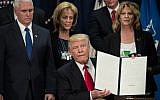 US President Donald Trump holds up an executive order to start the Mexico border wall project at the Department of Homeland Security facility in Washington, DC, on January 25, 2017. (AFP/Nicholas Kamm)
