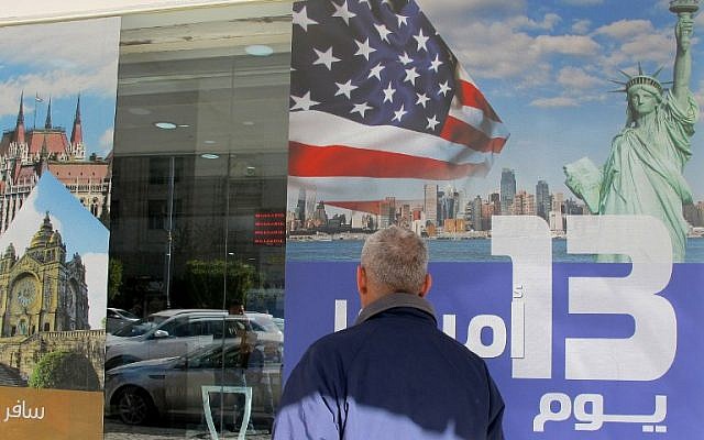 An Iraqi man stands next to an ad for a 13-day trip to the United States at a travel agency in the capital Baghdad on January 28, 2017, a day after US President Donald Trump signed a new executive order to suspend refugee arrivals and impose tough controls on travelers from seven mainly-Muslim countries, including Iraq. (AFP/Sabah Arar) An Iraqi man stands next to an ad for a 13-day trip to the United States at a travel agency in the capital Baghdad on January 28, 2017, a day after US President Donald Trump signed a new executive order to suspend refugee arrivals and impose tough controls on travelers from seven mainly-Muslim countries, including Iraq. (AFP/Sabah Arar)