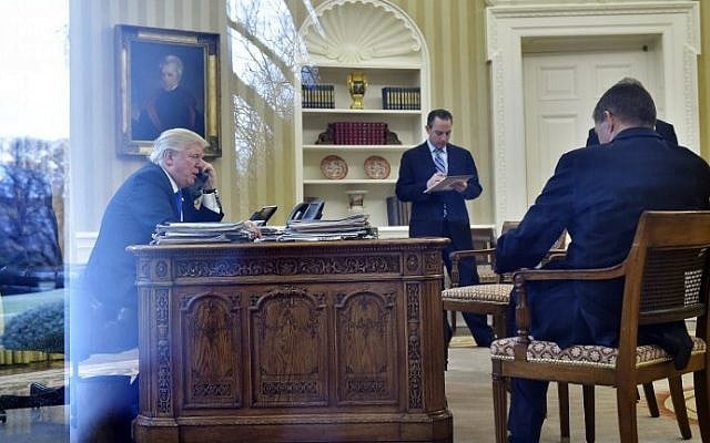 US President Donald Trump speaks on the phone with Germany's Chancellor Angela Merkel from the Oval Office of the White House on January 28, 2017 in Washington, DC.  (AFP PHOTO / MANDEL NGAN)