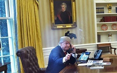 US President Donald Trump, left, seen through an Oval Office window, speaks on the phone to King Salman of Saudi Arabia in the Oval Office of the White House on January 29, 2017 in Washington, DC. (AFP/ Mandel Ngan)